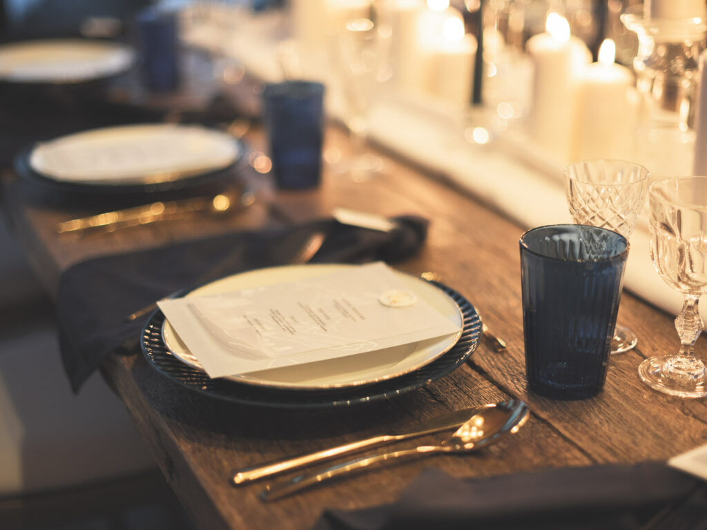 art de la table, mariage d'hiver, table en bois, verrerie bleue, menu, couverts, chemin de table, bougies, assiettes, décoration table de mariage