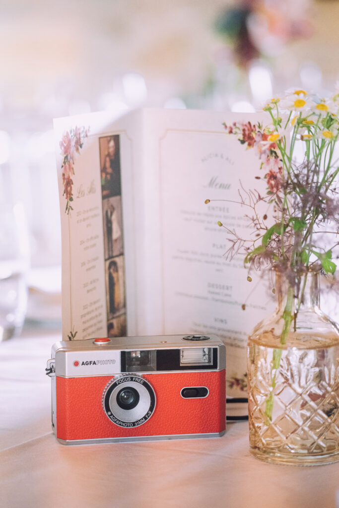 Menu pour papeterie de mariage avec appareil photo rouge et fleurs séchées
