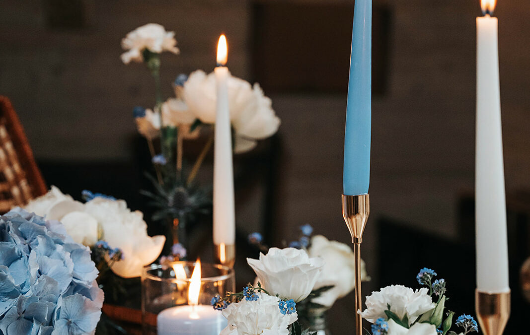 Bougies et fleurs blanches et bleues pour un centre de table de mariage couleurs tendances