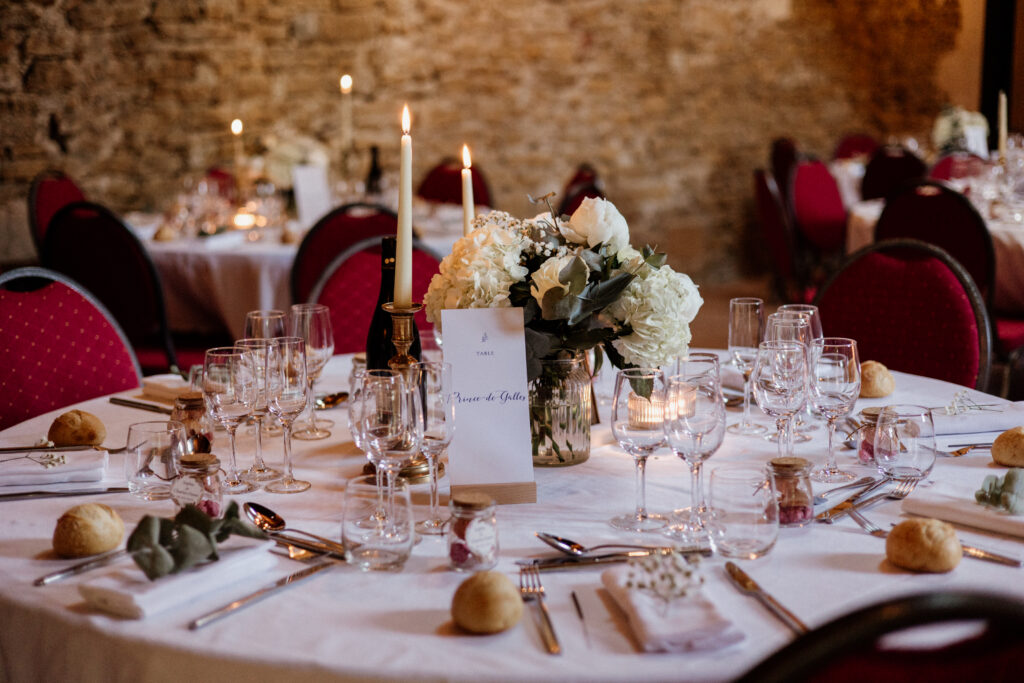 centre de table avec bouquet de fleurs, menu de mariage et bougies, table d'honneur