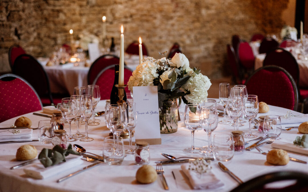 centre de table avec bouquet de fleurs, menu de mariage et bougies