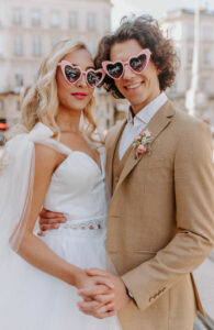 photo de couple, tram, robe e mariée, costume beige, fleurs, boutonnière, rose, pink, lunettes de soleil