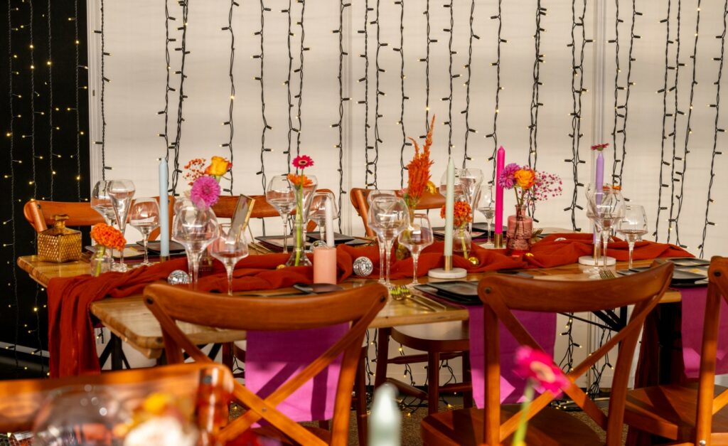 table en bois, serviette rose, art de la table, ciel étoilé, soliflore, fleurs, fleurs multicolores, chaise en bois, multicolores