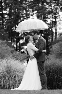 Séance photos de couple au pied d'un arbre sous un parapluie