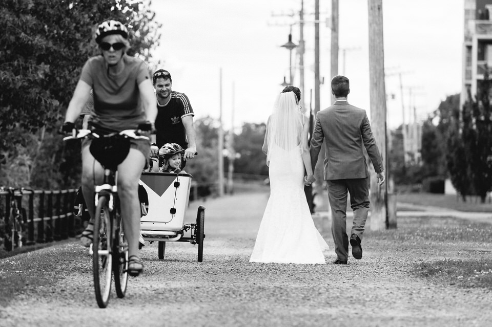 Noir et blanc, Mariés marchent de dos le long du Canal Lachine, Des passants à vélo croisent la route des mariés, Mariage en ville