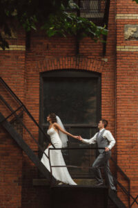 Mariés se tenant les mains en montant des escaliers, Séance photos de mariage, Planification par une wedding planner à Montréal, Mariage à Montréal à l'Espace Canal