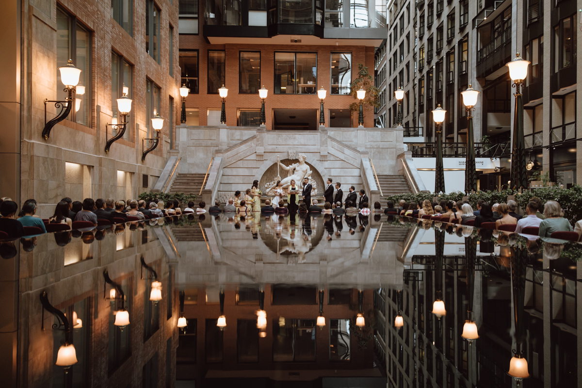 Cérémonie de mariage en cours au bout la fontaine dans le Centre de commerce mondial de Montréal, Planification par une wedding planner à Montréal, Mariage en intérieur illuminé