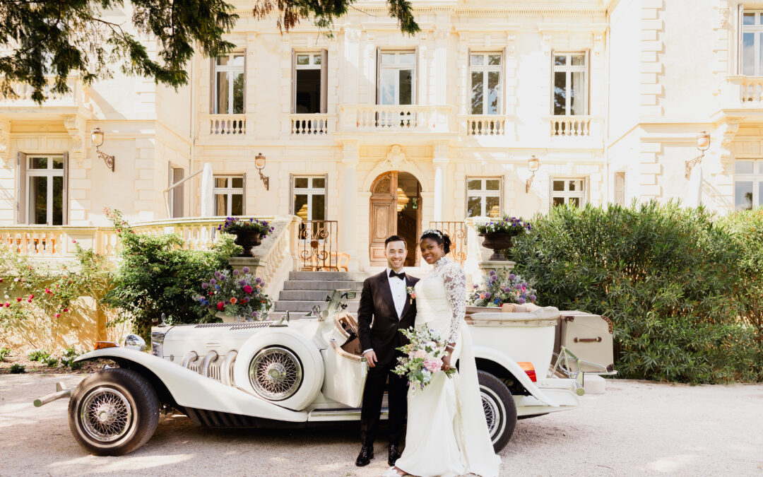 Photo de mariés devant la Château des trois Fontaines devant une ancienne voiture/ costume noir/ robe blanche